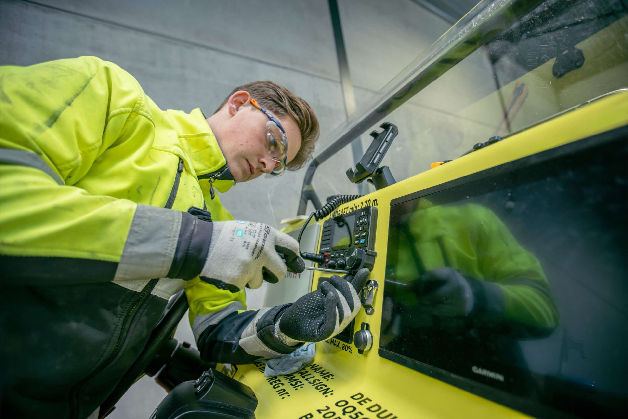 Technicus installeert communicatieapparatuur in een RIB-console