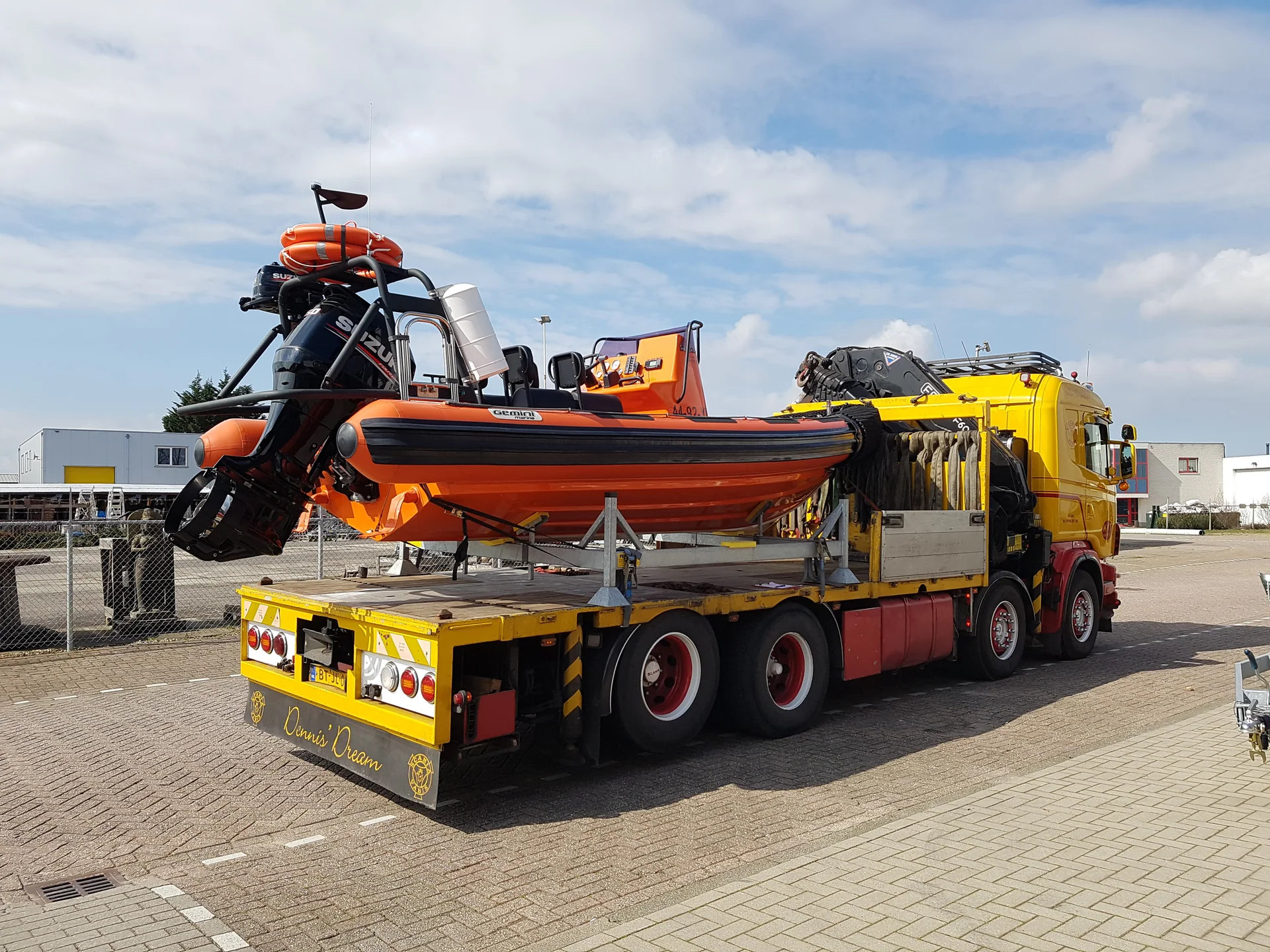 Oranje Gemini rescue RIB met buitenboordmotor en reddingsuitrusting op een transportvoertuig